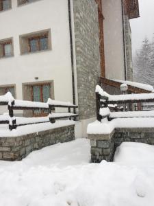 a snow covered fence in front of a building at Monolocale Campodolcino in Campodolcino