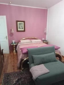 a bedroom with a bed with purple walls and a chair at Bike Civico 17 AFFITTA CAMERE in Venzone