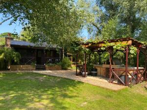 a garden with a pavilion in front of a house at Luxury Log Cabin with Outdoor Wood Fired Hot Tub & Pizza Oven in Ribchester