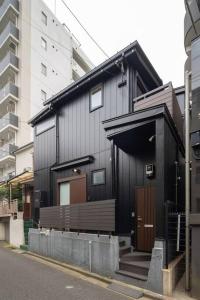 OCHANOMA في Ebisuchō: مبنى أسود مع مقعد على شارع المدينة