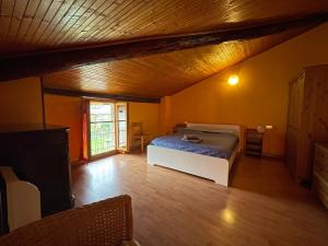 ein Schlafzimmer mit einem Bett und einer Holzdecke in der Unterkunft Da Rita in Crone