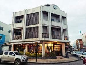 ein Gebäude mit einer Uhr auf der Vorderseite in der Unterkunft Nakorn De Sukhothai Hip Hotel in Sukhothai