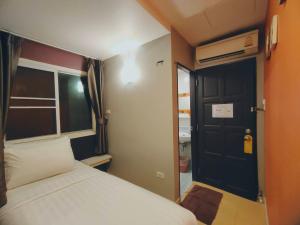 - une petite chambre avec un lit et une porte noire dans l'établissement BBHouse Phra Athit, à Bangkok