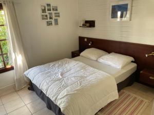 1 dormitorio con 1 cama grande con sábanas blancas en Maison Golvan centre ville avec parking et jardin en Quiberon