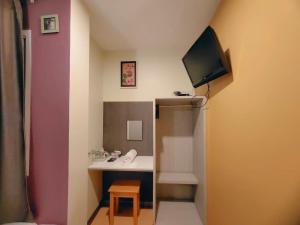 a small room with a desk and a tv on the wall at BBHouse Phra Athit in Bangkok