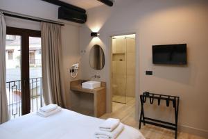 a bedroom with a bed and a bathroom with a shower at Anesis Hotel in Kalavrita