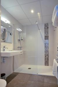 La salle de bains est pourvue d'une douche avec une porte en verre. dans l'établissement Hôtel Restaurant Le Relais des Gourmands, à Gramat