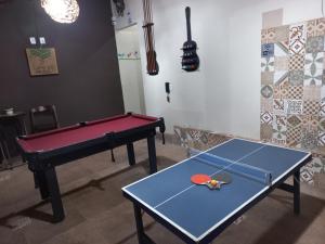 a room with two ping pong tables and a ping pong racket at Pousada Flores em Vida in Olímpia