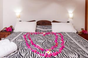 a bedroom with a bed with a zebra patterned blanket at Eden House Cottages in Malindi +84 photos