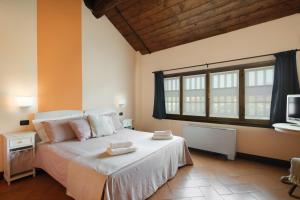 una camera da letto con un grande letto con asciugamani di Hotel Morimondo a Morimondo