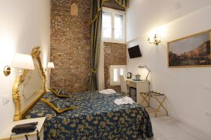 une chambre d'hôtel avec un lit, une table et une fenêtre dans l'établissement Al Mascaron Ridente, à Venise