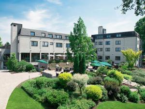 ein Gebäude mit einem Garten vor einem Gebäude in der Unterkunft See und Sporthotel Ankum Lakeside Apartments in Ankum