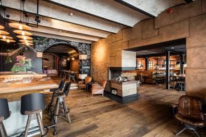 a restaurant with wooden floors and a bar with stools at Liebesbier Urban Art & Smart Hotel in Bayreuth