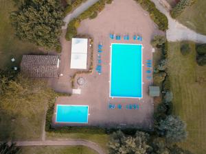 - une vue sur le court de tennis et la piscine dans l'établissement Relais San Clemente, à Pérouse