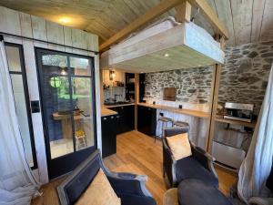 a living room with chairs and a kitchen in a house at La Demoiselle de Bohardy in Montrevault