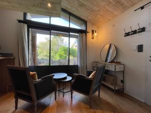 a dining room with a table and chairs and a window at La Demoiselle de Bohardy in Montrevault