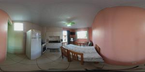 uma cozinha com uma mesa e um frigorífico num quarto em Pousada Barra da Lagoa em Florianópolis