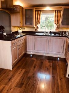 a kitchen with wooden floors and a sink and a stove at Rymmon Retreat in Orkney