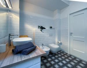 a white bathroom with a sink and a toilet at Guest House S Caterina in Viterbo