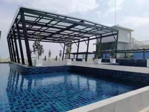 a swimming pool with a pergola next to a building at WL Homestay in Sitiawan