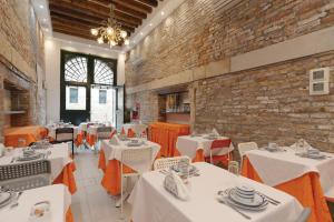 a restaurant with white tables and chairs and a brick wall at Al Mascaron Ridente in Venice