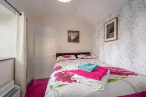 a bedroom with a bed with towels on it at Coastal cottage 'The Garden Cottage ' in Hartland