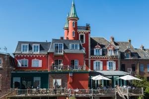 a large red building with a clock tower on top at Hotel Restaurant Les Tourelles in Le Crotoy