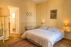 a bedroom with a large white bed in it at Hotel Restaurant Les Tourelles in Le Crotoy