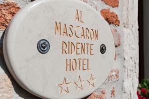 um sinal para um hotel de refúgio maçónico num desfiladeiro numa parede de tijolos em Al Mascaron Ridente em Veneza