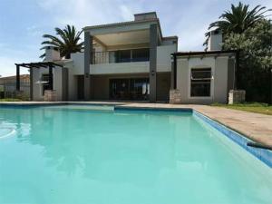 a large swimming pool in front of a house at Bougain Villas in Cape Town