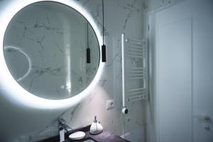 een badkamer met een grote spiegel en een wastafel bij TAM Serviced Apartment City Center No4 in Tirana