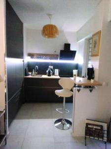 uma pequena cozinha com um balcão e um banco em NICE- GAIRAUT - JARDIN PRIVE- GRAND F1 LUMINEUX-Piscine Collective em Nice