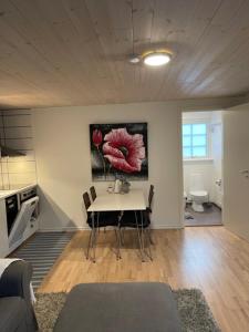 uma sala de estar com uma mesa e um quadro de flores em Båstad em Båstad