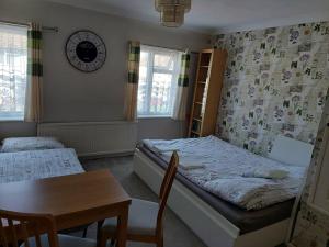Schlafzimmer mit einem Bett und einem Tisch sowie einem Tisch und Stühlen in der Unterkunft Home accommodation in Southampton