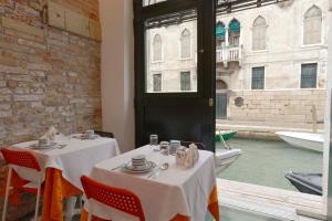 a restaurant with two tables and a view of a canal at Al Mascaron Ridente in Venice