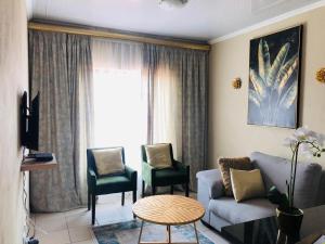 a living room with a couch and two chairs at Tshamani self catering in Hazyview