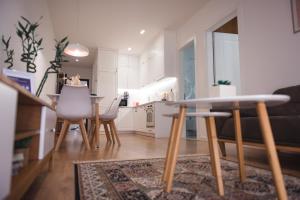 een keuken en een woonkamer met een tafel en stoelen bij TAM Serviced Apartment City Center No4 in Tirana