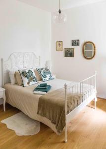 a white bed in a white bedroom with a bed frame at Delightful Villa Rina in Merano