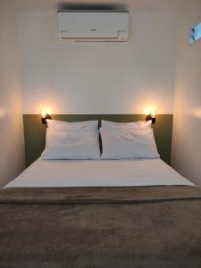 a bedroom with a bed with two white pillows at Rede Suítes in Maragogi