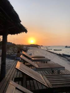 un grupo de bancos en la playa al atardecer en Kite Point Atins en Atins