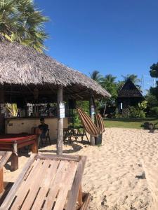 a beach with a hut and chairs on the sand at Kite Point Atins in Atins