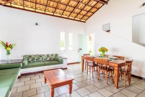 sala de estar con mesa y sofá verde en GB40 Casa 4 Suítes a 200m da Praia - Guarajuba, en Guarajuba