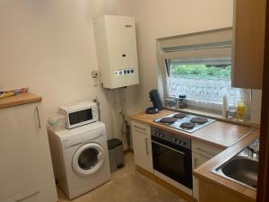 eine kleine Küche mit einer Waschmaschine und einer Mikrowelle in der Unterkunft Ruhiges zentral gelegenes Apartment in Gütersloh in Gütersloh