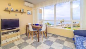 Sala de estar con mesa de comedor y TV en Cubo's Urban Beach Algarrobo en Algarrobo