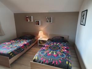 1 dormitorio con 2 camas y mesa con lámpara en Belle villa calme à la montagne en Saint-Michel-de-Chaillol