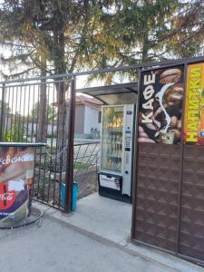 a drink vending machine next to a fence at Квартири ЦЕНТРАЛ in Dolna Mitropoliya