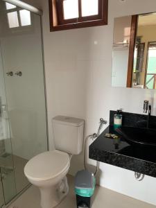 a bathroom with a toilet and a sink and a mirror at Pousada Sossego in Lavras Novas