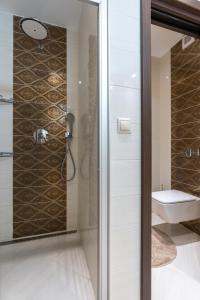 uma casa de banho com um chuveiro, um WC e um lavatório. em Apartment Rose Chopok 1100 m-on hiking trail-view-hot tub-sauna-view em Demanovska Dolina