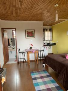 Zimmer mit einem Bett, einem Tisch und Stühlen in der Unterkunft Pousada Sossego in Lavras Novas