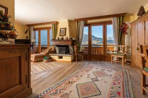 a living room with a fireplace and a mountain view at Chalet Casericc in Bormio